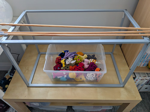 metal frame, wooden dowels and a box of crocheted fish and corals - the start of a crocheted aquarium