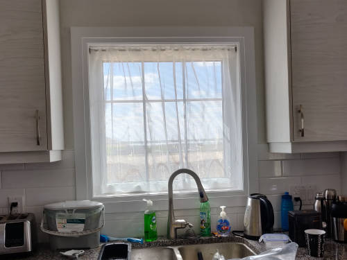 sheer curtain hanging in the kitchen window