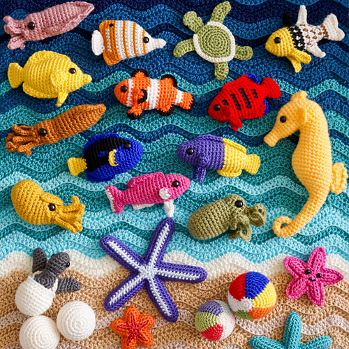 a crochet beach blanket with a selection of amigurumi fish, seahorses, turtles, starfish, cephalopods, etc, all made from PlanetJune patterns