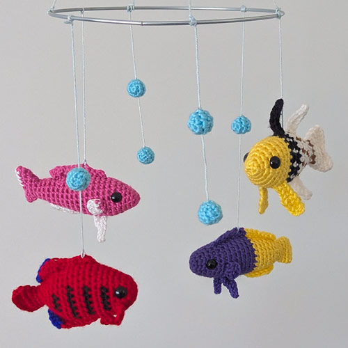 a mobile with colourful amigurumi fish and blue crocheted bubbles