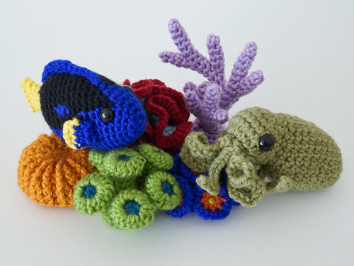 crocheted corals with an amigurumi blue tang fish and octopus on a white background