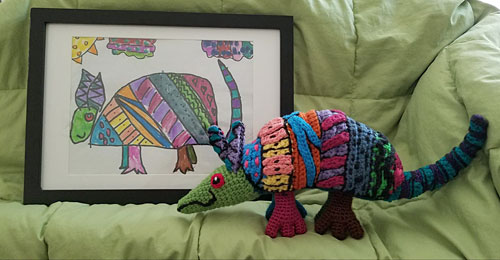 Maureen's crocheted armadillo with Isabella's armadillo drawing